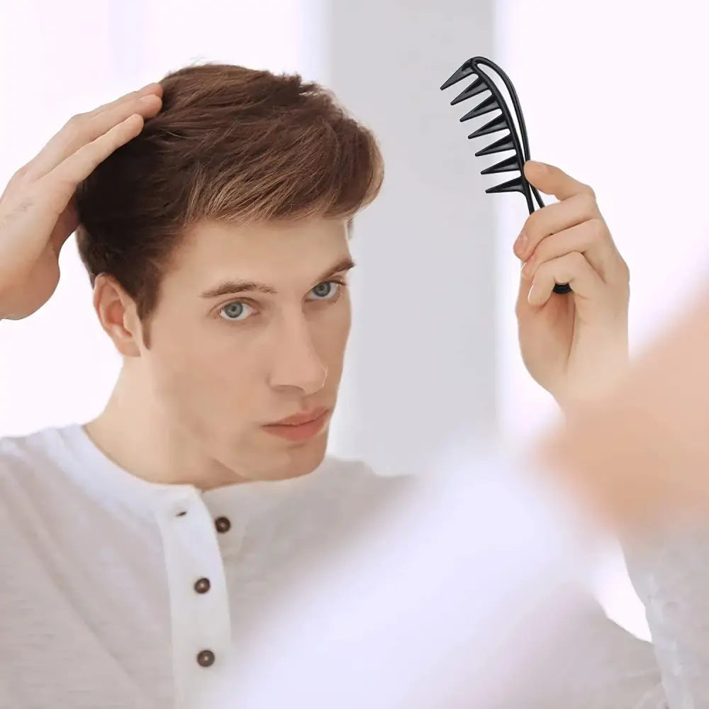 Wide-toothed comb held by a hand.