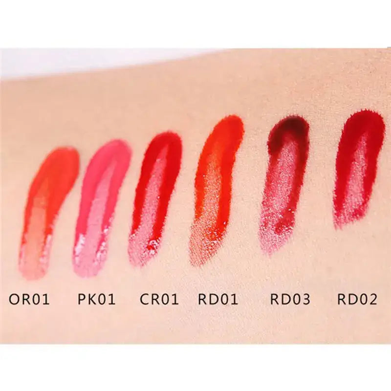 Swatches of lipstick or lip gloss in various shades of red and pink.