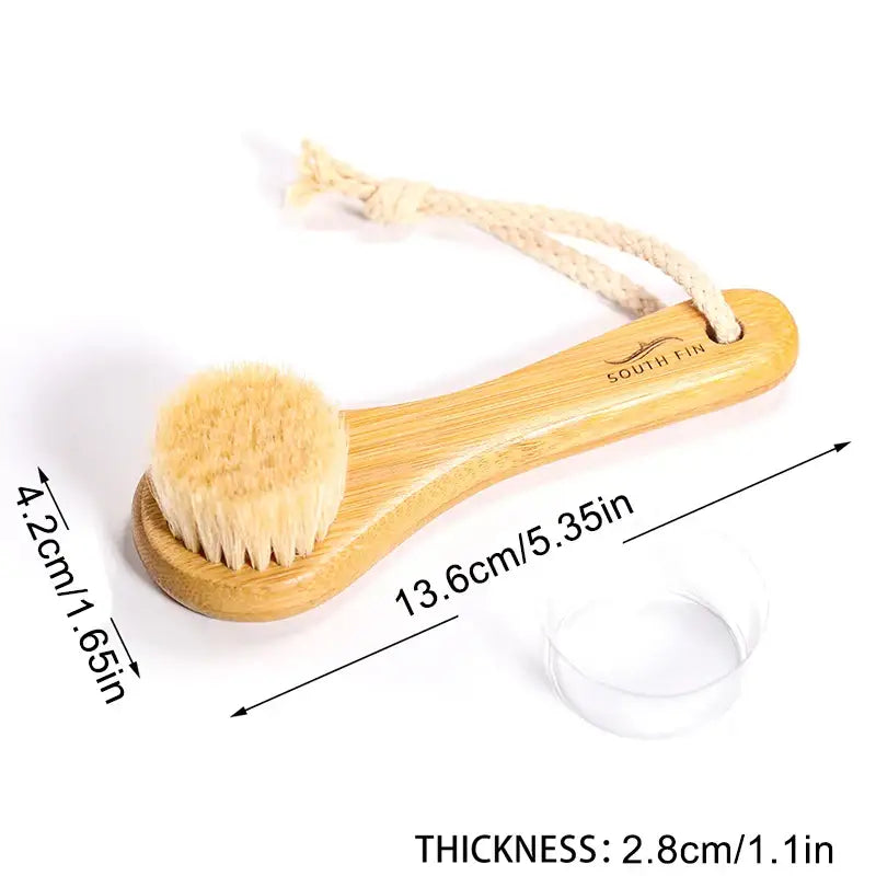 Wooden-handled facial cleansing brush with soft bristles and a hanging cord.